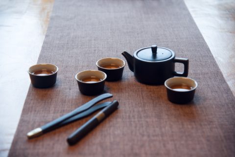 Cup and tea set with tea on table
